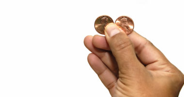 hand holding two pennies